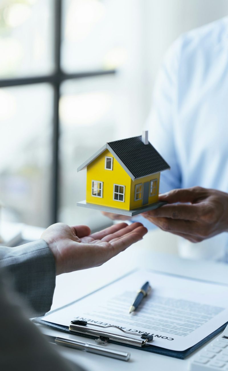 real estate home is pointing to insurance contract signing and are explaining to customers.